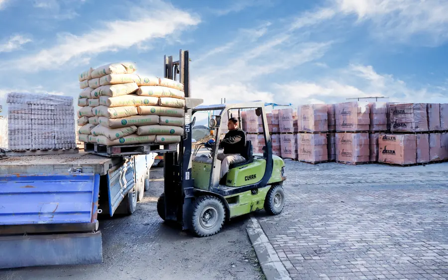 Forkliftle kamyona yüklenen çimento çuvalları